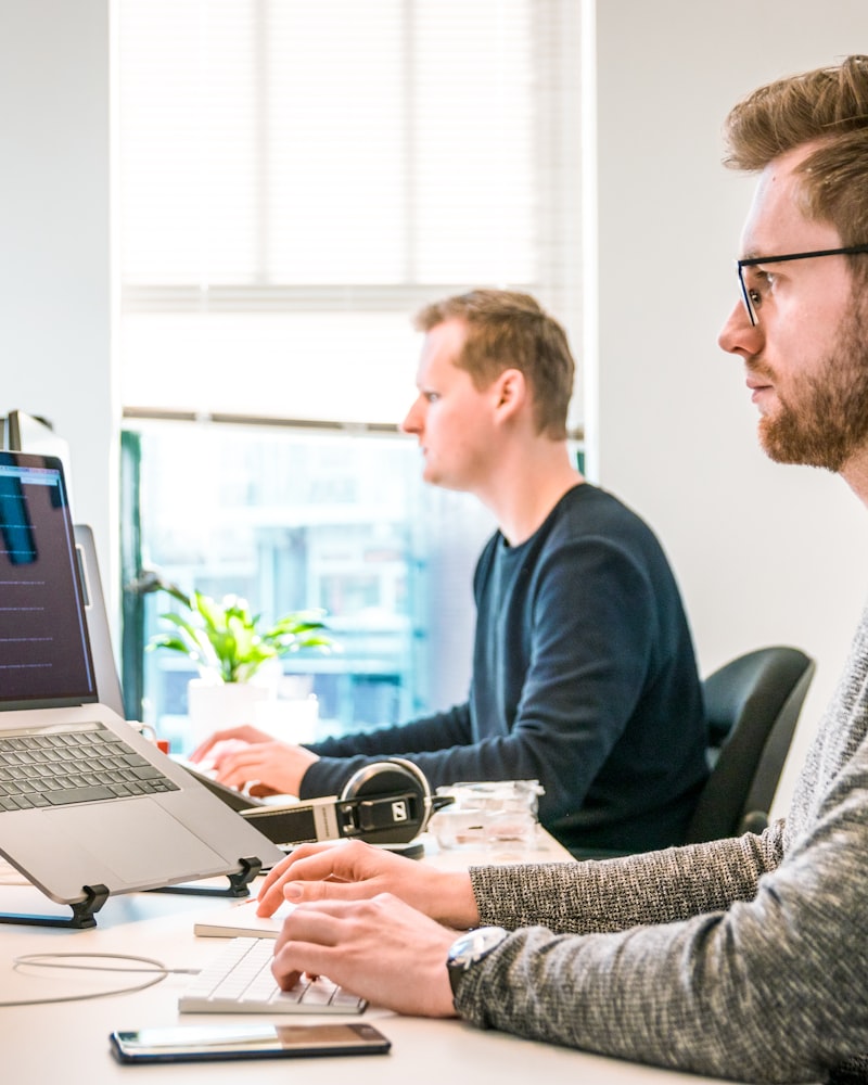 Équipe de l'agence en train de coder côte à côte sur portables, lumière naturelle de bureau lumineux à Gatineau