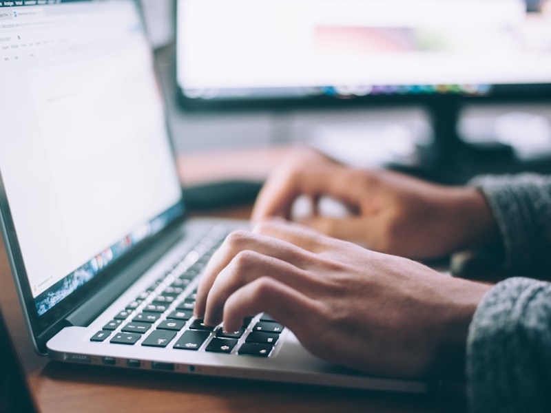 Mains qui tapent sur un MacBook — entretien continu et mises à jour